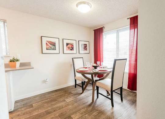 A dining room with a table set for two and a potted plant on the windowsill at Altitude Apartment , Tacoma