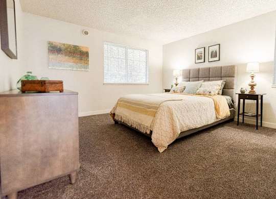 A bedroom with a bed, nightstand, and a painting on the wall at Altitude Apartment , Washington
