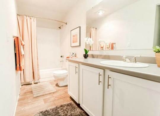 A bathroom with a toilet, sink, and shower at Altitude Apartment , Tacoma