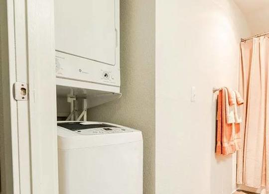 A white dryer is sitting in a small closet at Altitude Apartment , Tacoma, 98444