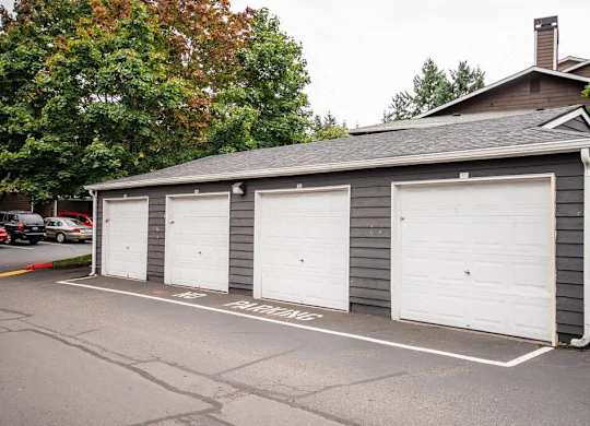 A grey building with three white garage doors at Altitude Apartment , Tacoma, Washington