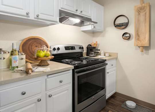 A modern kitchen with a stove top oven and white cabinets.