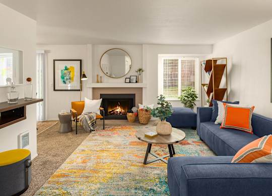 A living room with a fireplace and a blue couch.
