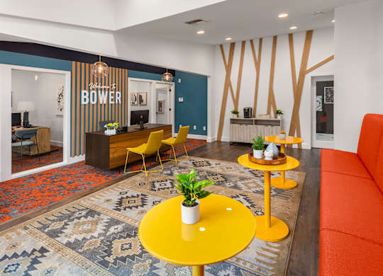 A living room with a yellow table and orange couch.