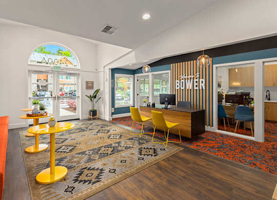 A room with a yellow table and a carpet with a pattern on it.