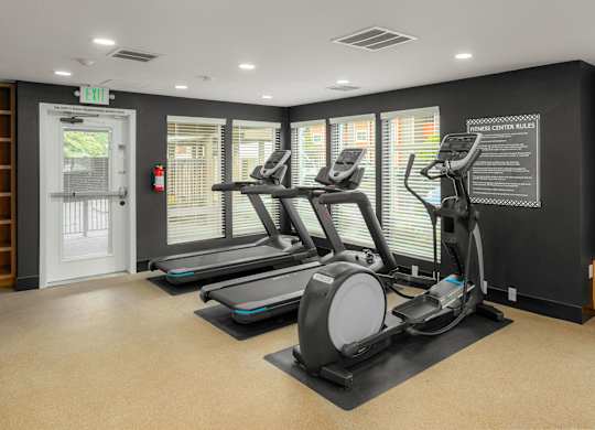 A gym with treadmills and a sign that says
