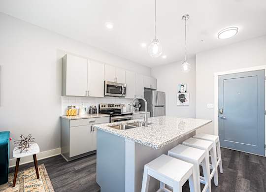 a kitchen with a marble counter top and white cabinets