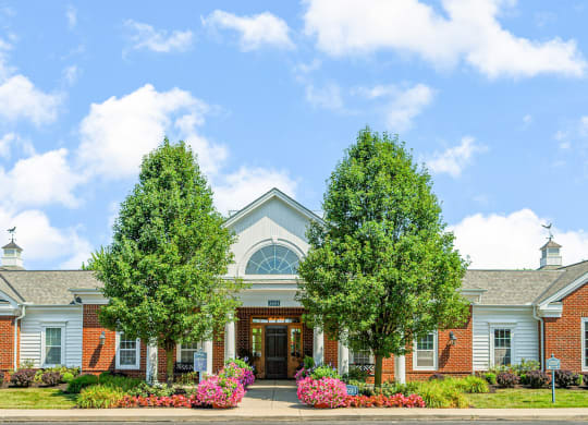 the front of a building with two trees in front of it