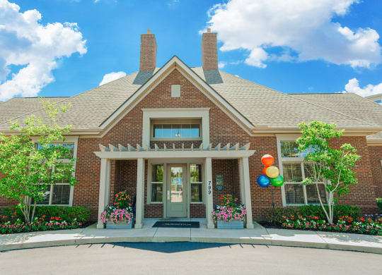 the front of a brick house with balloons on the side