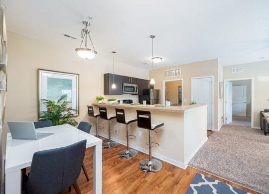 an open kitchen and dining area with a bar and a living room