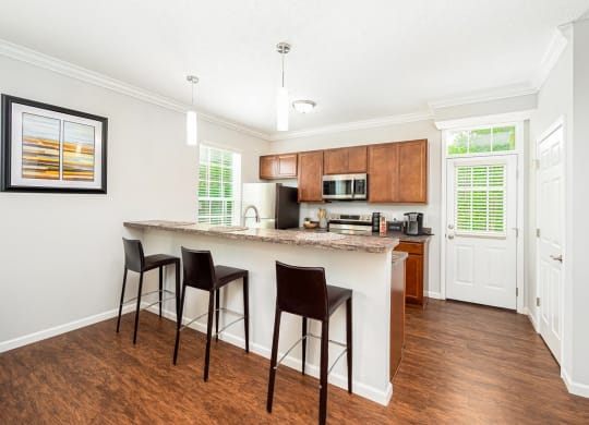 a kitchen with a bar with three stools