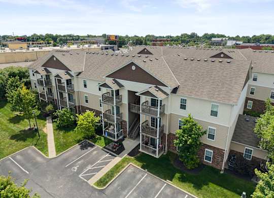 Apartment complex with a parking lot in front.