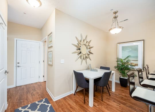 a dining room with a table and chairs and a mirror