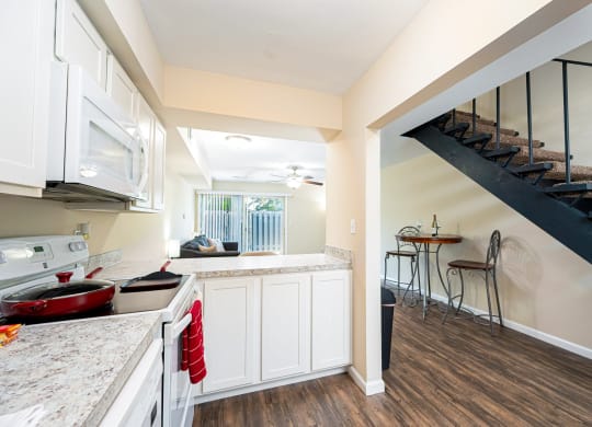 a kitchen with a sink and a stove and a staircase