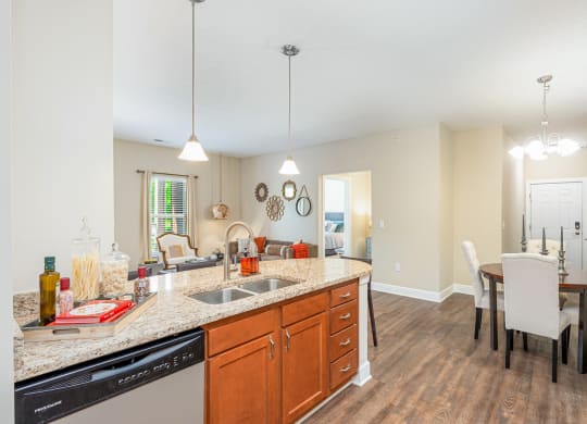 a kitchen with a sink and a dining room with a table