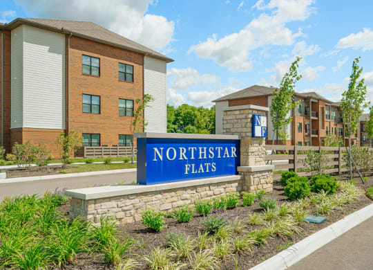 a sign flats in front of an apartment building