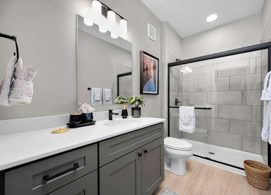 A bathroom with a white countertop and a white toilet.