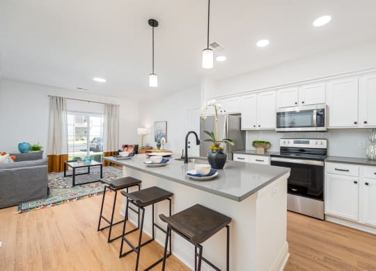 an open kitchen with a large island with three stools