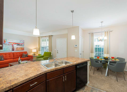 an open kitchen and living room with a dining room table and chairs