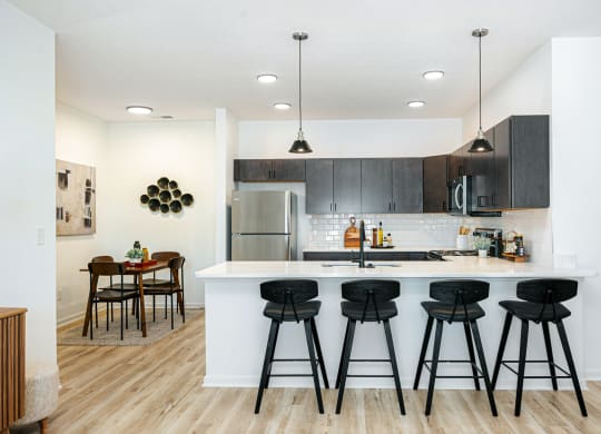 a kitchen with a large island with bar stools