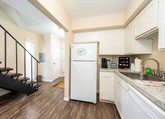 a kitchen with white cabinets and a white refrigerator