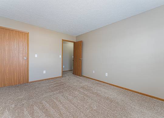 A room with carpeted floor and two doors
