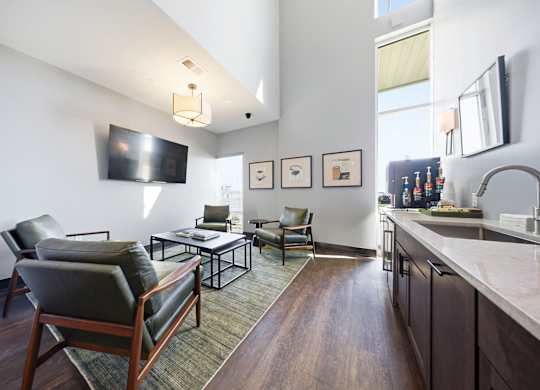 A modern living room with a dark wood floor and furniture.