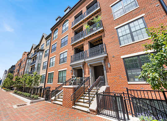 A red brick building with a black metal railing.
