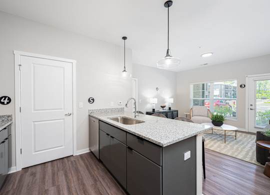 A kitchen with a white counter top and a black dishwasher.