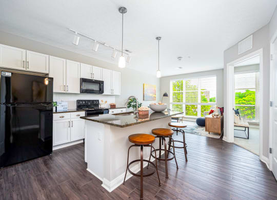 a kitchen with a large island with three stools