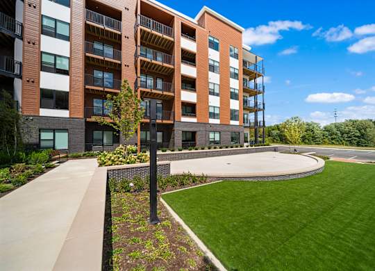 A modern apartment building with a well-maintained lawn in front.