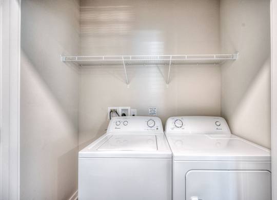 A small laundry room with a washer and dryer.