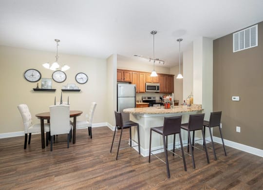 an open kitchen and dining area with a marble counter top