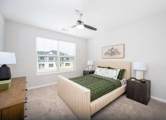 A bedroom with a large bed and a ceiling fan.