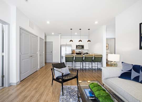 A modern living room with a grey sofa and a glass coffee table.