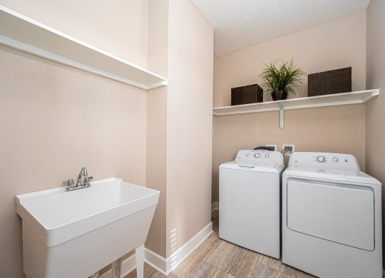 a laundry room with a sink and a washer and dryer