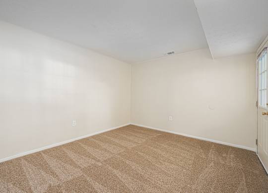 an empty room with carpet and a door