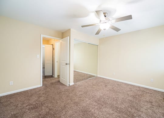 a room with carpet and a ceiling fan