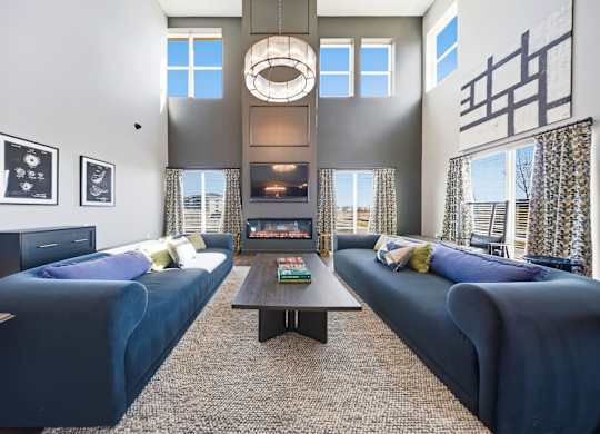 A living room with two blue couches and a coffee table.