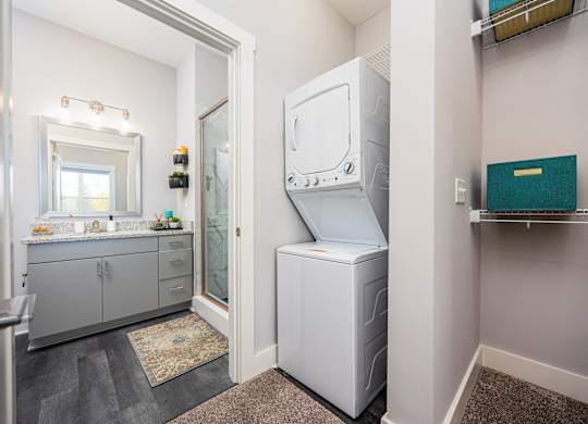 a washer and dryer in a laundry room with a sink and a mirror