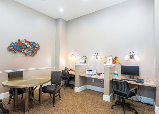 a conference room with a round table and a desk with a computer