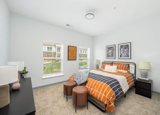 a bedroom with a bed and two windows