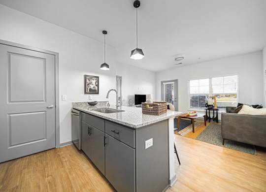 A kitchen with a white counter top and grey cabinets.