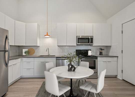 A modern kitchen with a white table and chairs.