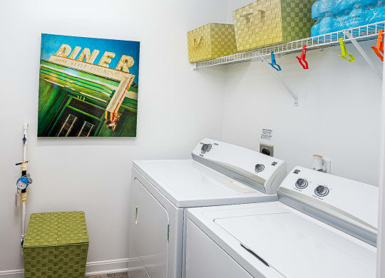 a laundry room with two washing machines and a painting on the wall