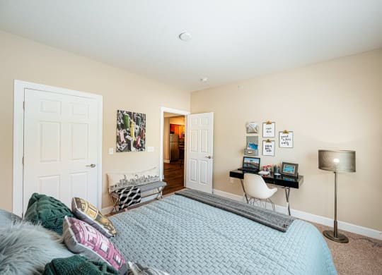 a bedroom with a bed and a desk with a chair