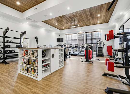 A gym with a variety of equipment including weights and cardio machines.