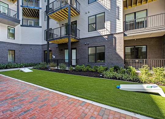 A modern apartment complex with a red brick walkway.