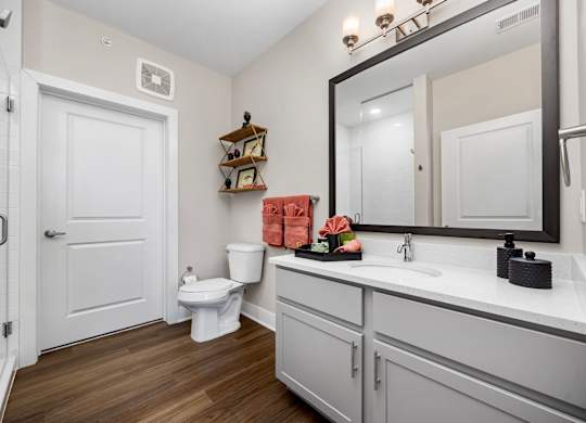 A white bathroom with a toilet, sink, and mirror.