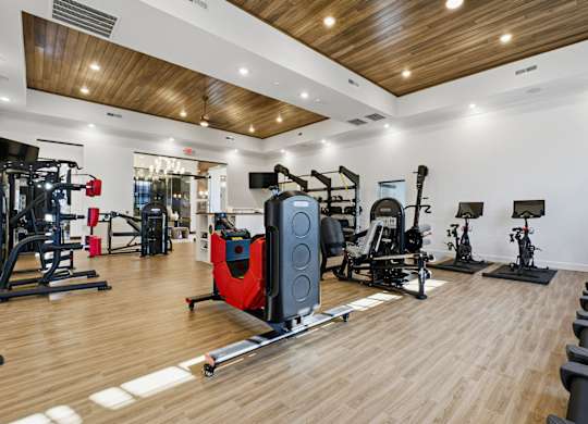 A gym with a variety of equipment including a rowing machine.